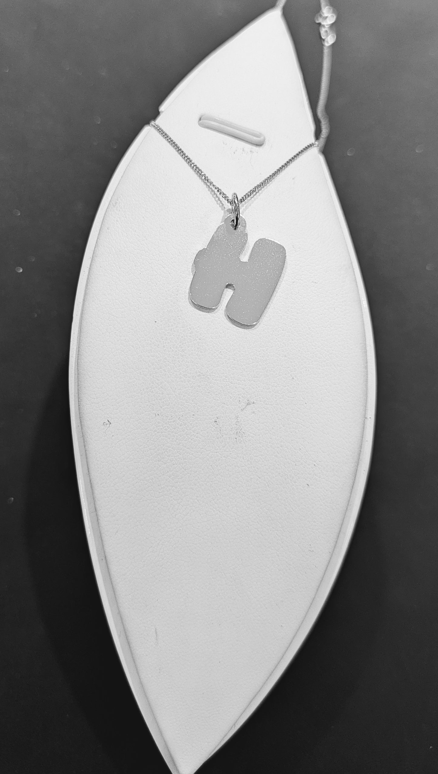 Laser-cut sterling silver H pendant with a sleek finish.